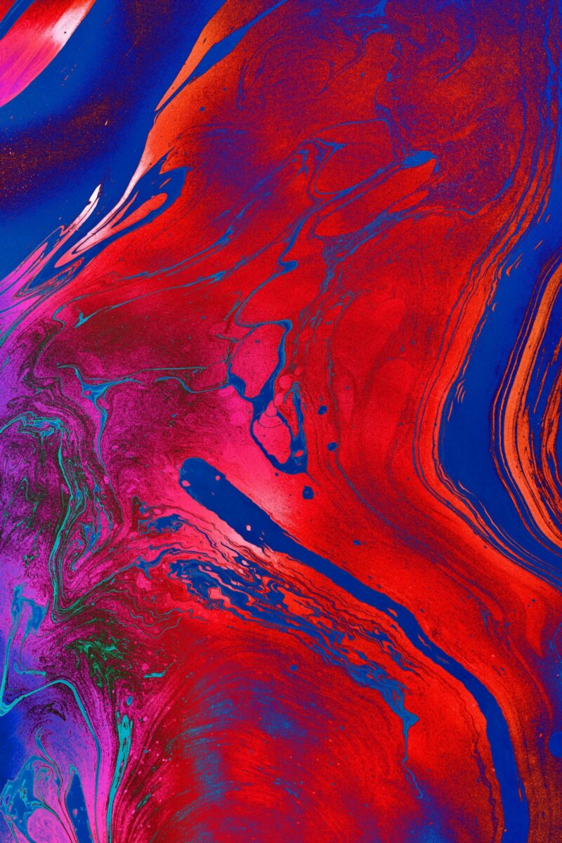 Dynamic and colorful abstract painting with bold fluid patterns in red, blue, and purple hues.